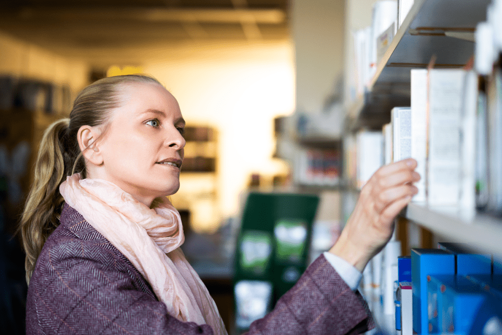 Woman looking at different medication boxes on a shelf