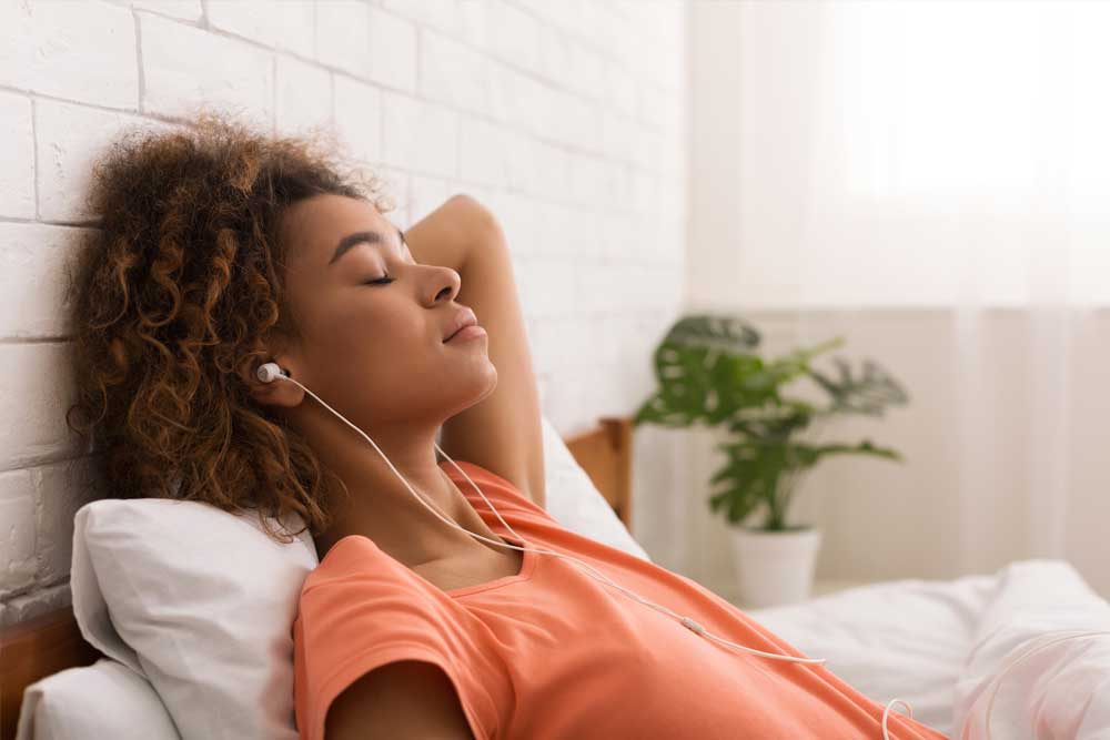 A woman relaxing , listening to music